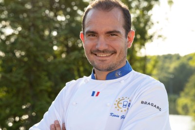 Sculpture moderne d'un taureau noir aux cornes longues et rouges, avec une posture dynamique et stylisée.