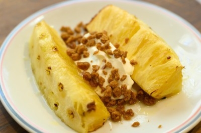 Assiette de magret de canard tranché sur purée de patates douces, garnie de persil et accompagnée d'une sauce.