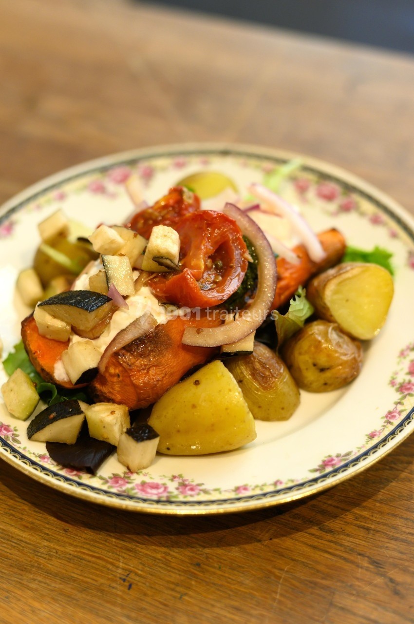 Assiette de légumes rôtis variés avec pommes de terre, aubergines, tomates et oignons sur un plat décoré.