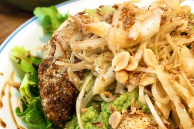 Assiette de magret de canard tranché sur purée de patates douces, garnie de persil et accompagnée d'une sauce.