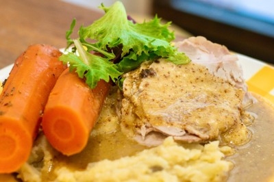 Assiette de magret de canard tranché sur purée de patates douces, garnie de persil et accompagnée d'une sauce.