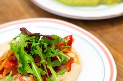 Assiette de magret de canard tranché sur purée de patates douces, garnie de persil et accompagnée d'une sauce.
