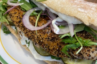 Assiette de magret de canard tranché sur purée de patates douces, garnie de persil et accompagnée d'une sauce.