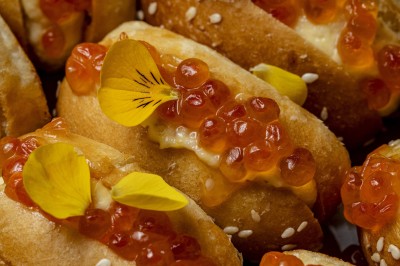 Assortiment de bouchées apéritives avec blinis au saumon et mini-sandwichs garnis d'œufs de poisson et de crème.