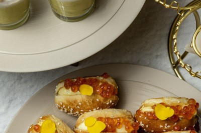 Assortiment de bouchées apéritives avec blinis au saumon et mini-sandwichs garnis d'œufs de poisson et de crème.