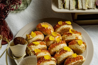 Assortiment de bouchées apéritives avec blinis au saumon et mini-sandwichs garnis d'œufs de poisson et de crème.