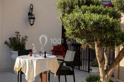 Dessert au glaçage chocolat brillant, garni de noisettes entières et concassées, présenté sur une assiette blanche.