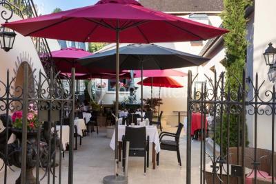 Dessert au glaçage chocolat brillant, garni de noisettes entières et concassées, présenté sur une assiette blanche.