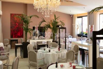 Dessert au glaçage chocolat brillant, garni de noisettes entières et concassées, présenté sur une assiette blanche.