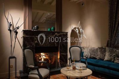 Dessert au glaçage chocolat brillant, garni de noisettes entières et concassées, présenté sur une assiette blanche.