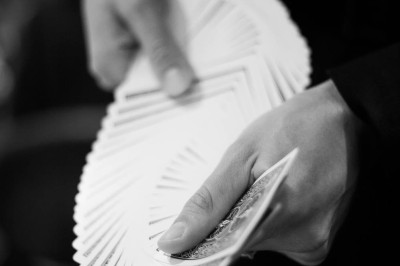 Femme assise dans une lumière tamisée, entourée de verres, regardant vers l'objectif.
