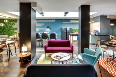 Miniature Location salle Paris 18 (Paris) - Terrass' Hotel #8 Chambre lumineuse avec un lit double, des murs sombres, une verrière, un fauteuil bleu et des rideaux blancs et bleus.