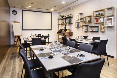 Miniature Location salle Paris 18 (Paris) - Terrass' Hotel #3 Chambre lumineuse avec un lit double, des murs sombres, une verrière, un fauteuil bleu et des rideaux blancs et bleus.