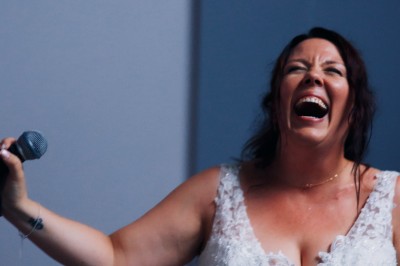 Chat tigré beige et brun bâillant, allongé sur un fauteuil bleu dans un intérieur lumineux.