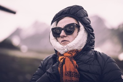 Chat tigré beige et brun bâillant, allongé sur un fauteuil bleu dans un intérieur lumineux.