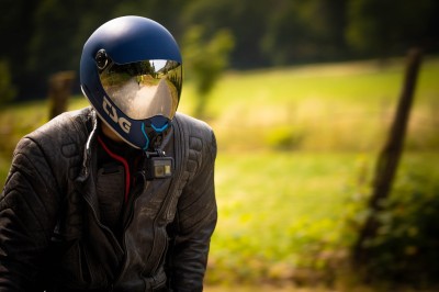 Chat tigré beige et brun bâillant, allongé sur un fauteuil bleu dans un intérieur lumineux.