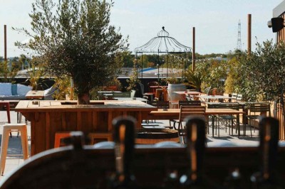 Des personnes jouent à un jeu interactif projeté sur un mur, utilisant des ballons pour toucher des cibles lumineuses.
