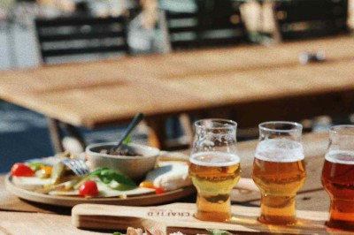 Des personnes jouent à un jeu interactif projeté sur un mur, utilisant des ballons pour toucher des cibles lumineuses.