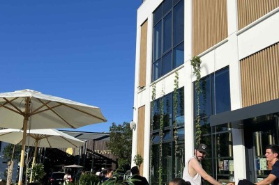 Des personnes jouent à un jeu interactif projeté sur un mur, utilisant des ballons pour toucher des cibles lumineuses.