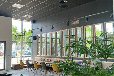 Des personnes jouent à un jeu interactif projeté sur un mur, utilisant des ballons pour toucher des cibles lumineuses.