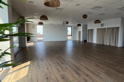 Des personnes jouent à un jeu interactif projeté sur un mur, utilisant des ballons pour toucher des cibles lumineuses.