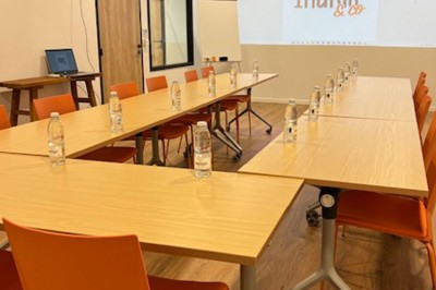 Des personnes jouent à un jeu interactif projeté sur un mur, utilisant des ballons pour toucher des cibles lumineuses.