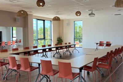 Des personnes jouent à un jeu interactif projeté sur un mur, utilisant des ballons pour toucher des cibles lumineuses.