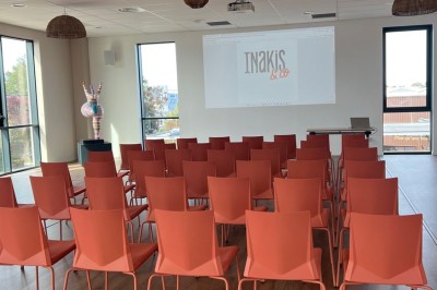 Des personnes jouent à un jeu interactif projeté sur un mur, utilisant des ballons pour toucher des cibles lumineuses.