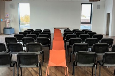 Des personnes jouent à un jeu interactif projeté sur un mur, utilisant des ballons pour toucher des cibles lumineuses.