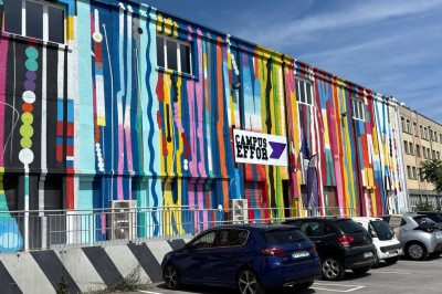 Lavabo double avec miroir, distributeur de papier et éclairage naturel dans une salle de bain aux murs blancs.