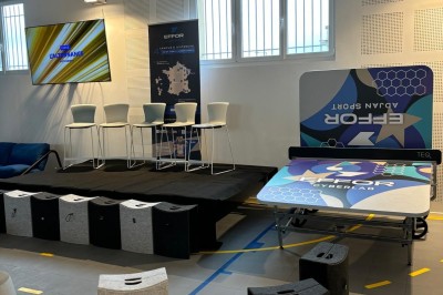 Lavabo double avec miroir, distributeur de papier et éclairage naturel dans une salle de bain aux murs blancs.