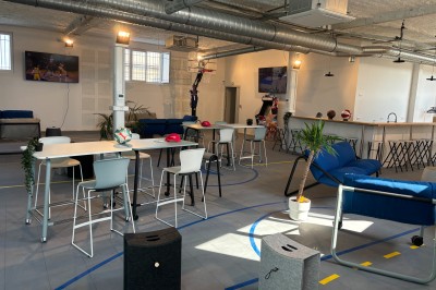 Lavabo double avec miroir, distributeur de papier et éclairage naturel dans une salle de bain aux murs blancs.