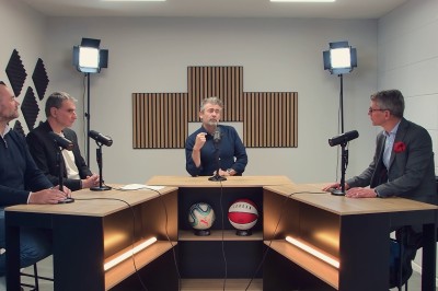 Lavabo double avec miroir, distributeur de papier et éclairage naturel dans une salle de bain aux murs blancs.