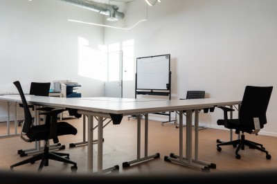 Lavabo double avec miroir, distributeur de papier et éclairage naturel dans une salle de bain aux murs blancs.