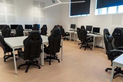 Lavabo double avec miroir, distributeur de papier et éclairage naturel dans une salle de bain aux murs blancs.