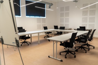 Lavabo double avec miroir, distributeur de papier et éclairage naturel dans une salle de bain aux murs blancs.