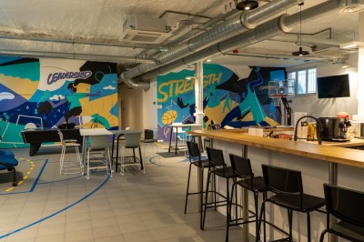 Lavabo double avec miroir, distributeur de papier et éclairage naturel dans une salle de bain aux murs blancs.