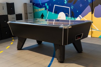 Lavabo double avec miroir, distributeur de papier et éclairage naturel dans une salle de bain aux murs blancs.