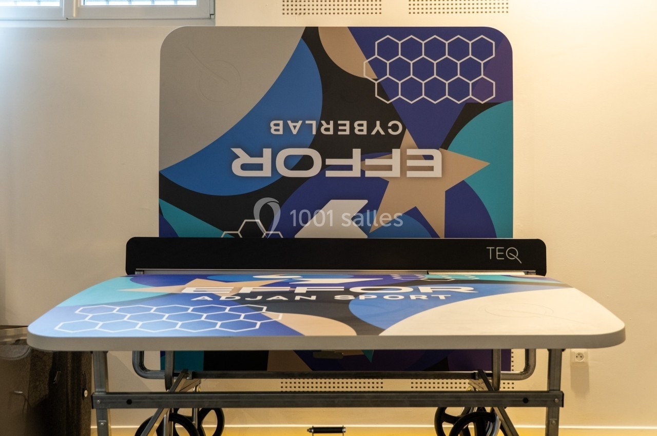 Table de Teqball pliée avec un design coloré et des motifs géométriques, posée dans une pièce lumineuse.