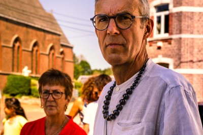 Un homme et une femme dansent ensemble lors d'un événement, entourés de plusieurs personnes en arrière-plan.