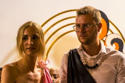 Un homme et une femme dansent ensemble lors d'un événement, entourés de plusieurs personnes en arrière-plan.