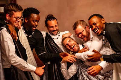 Un homme et une femme dansent ensemble lors d'un événement, entourés de plusieurs personnes en arrière-plan.