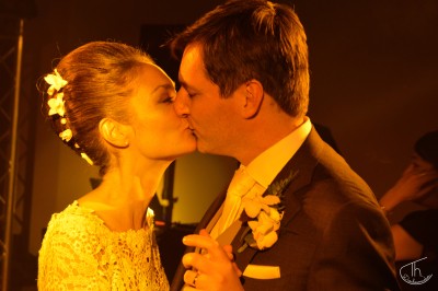 Un homme et une femme dansent ensemble lors d'un événement, entourés de plusieurs personnes en arrière-plan.