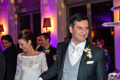 Un homme et une femme dansent ensemble lors d'un événement, entourés de plusieurs personnes en arrière-plan.