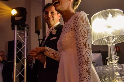 Un homme et une femme dansent ensemble lors d'un événement, entourés de plusieurs personnes en arrière-plan.