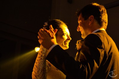 Un homme et une femme dansent ensemble lors d'un événement, entourés de plusieurs personnes en arrière-plan.