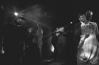 Un homme et une femme dansent ensemble lors d'un événement, entourés de plusieurs personnes en arrière-plan.