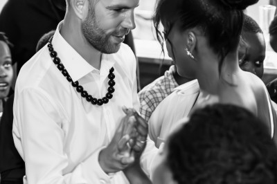 Un homme et une femme dansent ensemble lors d'un événement, entourés de plusieurs personnes en arrière-plan.