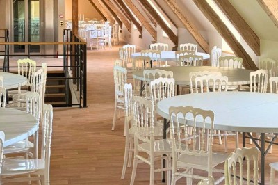 Miniature Location salle Magny (Yonne) - Château de Marrault #21 Jardin ensoleillé avec pelouse, puits en pierre, cyprès et bâtiment en pierre sous un ciel bleu dégagé.