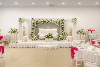 Miniature Location salle Fontenay-Trésigny (Seine-et-Marne) - L'Ecrin des Joyaux #4 Décor de mariage avec canapé blanc, table assortie et fleurs blanches et vertes sur une estrade ornée.